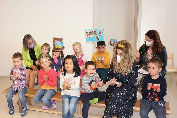 Eine Gruppe von Kindergartenkindern singt und musiziert mit ihren Betreuerinnen im Rahmen der Eröffnungsfeier.