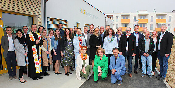 Die Ehrengäste bei der Eröffnung des neuen Kindercampus in der Getreidestraße vor dem Eingang des Kindergartens bei einem gemeinsamen Gruppenfoto.