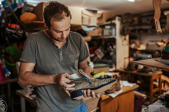 Ein Mitarbeiter inspiziert einen Schuh 